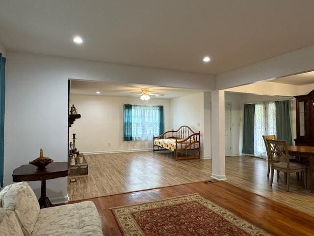 living room featuring hardwood / wood-style flooring, ceiling fan, plenty of natural light, and ornate columns