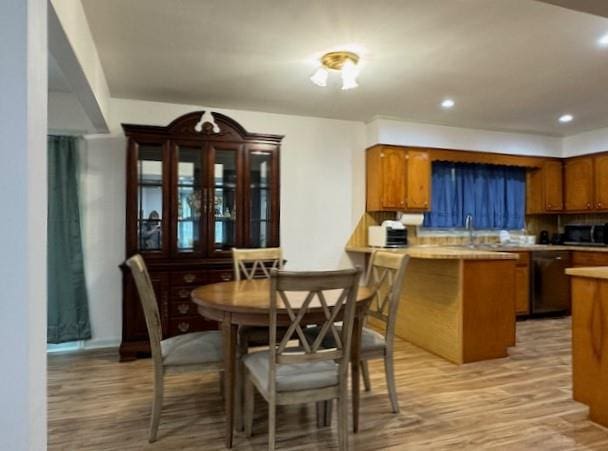 dining space featuring light wood-type flooring and sink