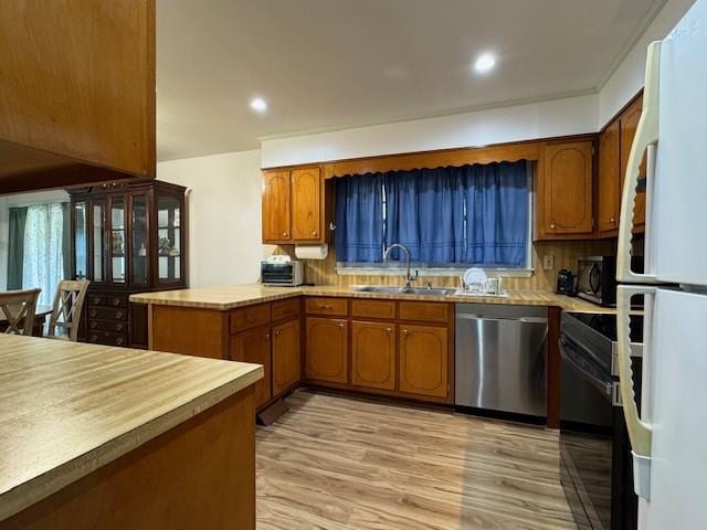 kitchen featuring white refrigerator, kitchen peninsula, sink, stainless steel dishwasher, and light hardwood / wood-style flooring