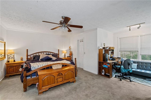 carpeted bedroom with a textured ceiling, baseboards, crown molding, and a ceiling fan