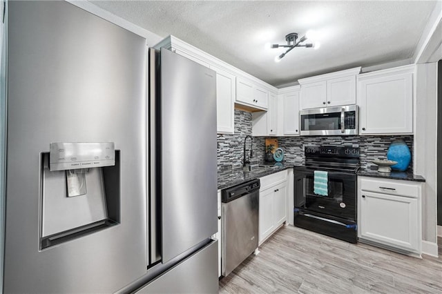 kitchen featuring tasteful backsplash, white cabinetry, appliances with stainless steel finishes, and light hardwood / wood-style floors