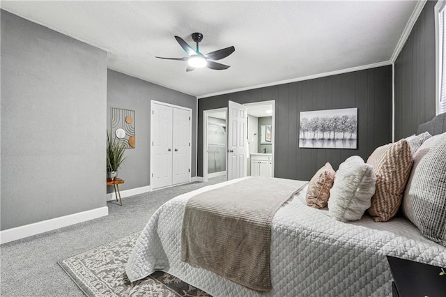 bedroom with ensuite bathroom, crown molding, wooden walls, carpet floors, and ceiling fan