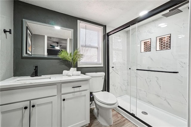 bathroom with hardwood / wood-style floors, vanity, an enclosed shower, a textured ceiling, and toilet