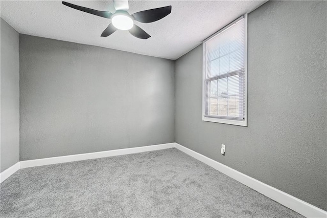 empty room featuring ceiling fan, carpet, and a textured ceiling