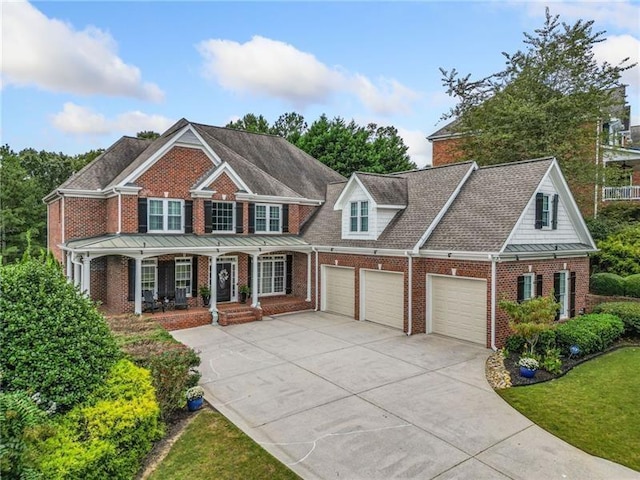 view of front of house with a garage, covered porch, and a front lawn