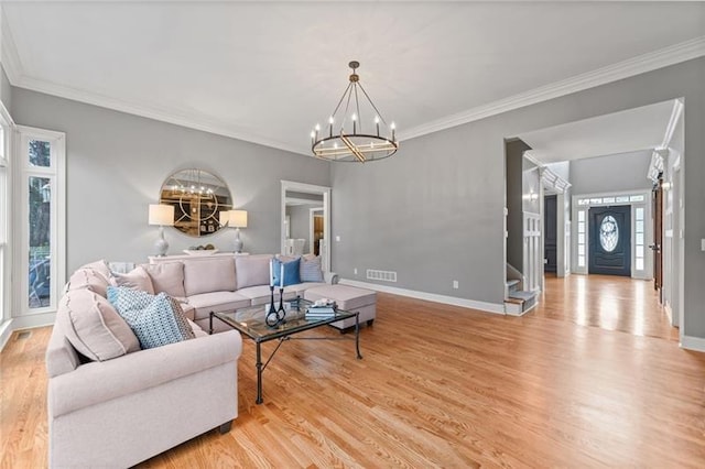 living room featuring crown molding, light hardwood / wood-style flooring, and a notable chandelier