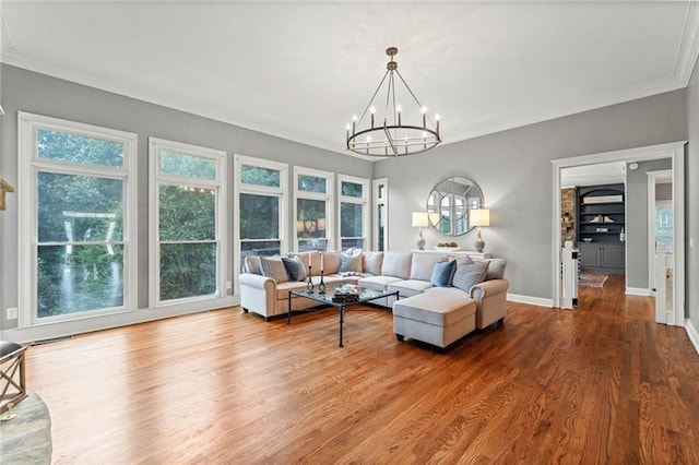 living room featuring wood-type flooring, ornamental molding, and a chandelier