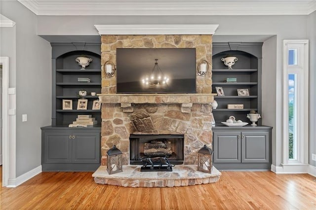 living room with ornamental molding, a stone fireplace, and light wood-type flooring