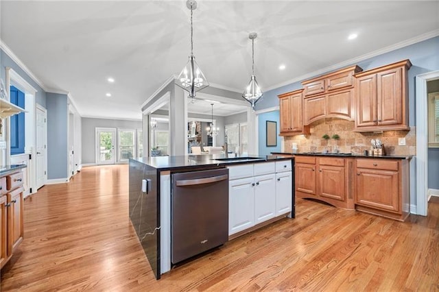 kitchen featuring sink, hanging light fixtures, a kitchen island, stainless steel dishwasher, and a chandelier