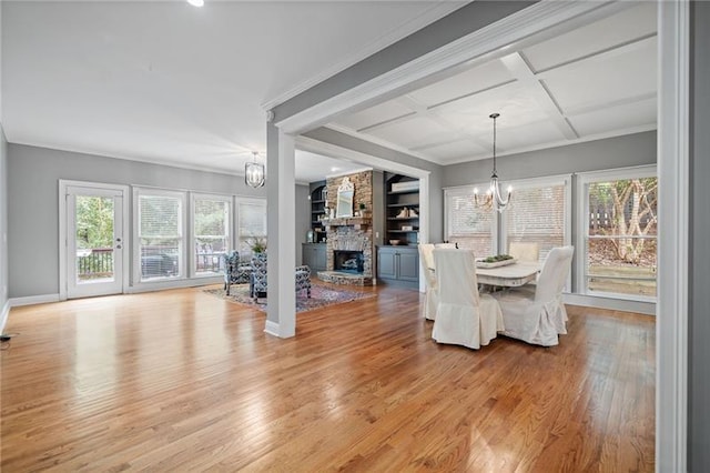 unfurnished dining area featuring crown molding, coffered ceiling, a notable chandelier, and light hardwood / wood-style floors