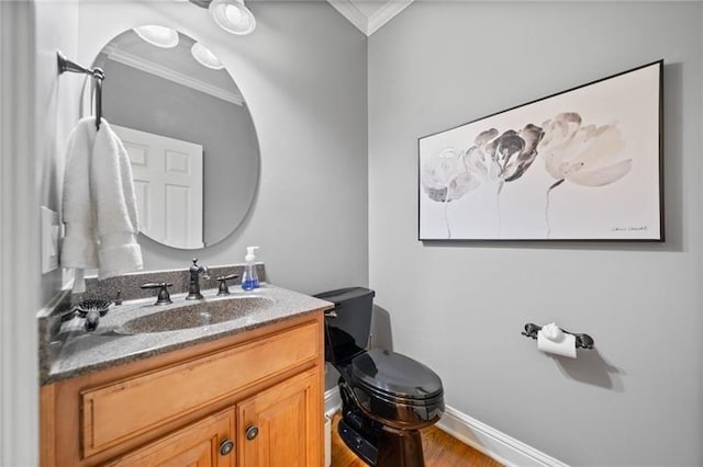 bathroom featuring hardwood / wood-style flooring, ornamental molding, vanity, and toilet