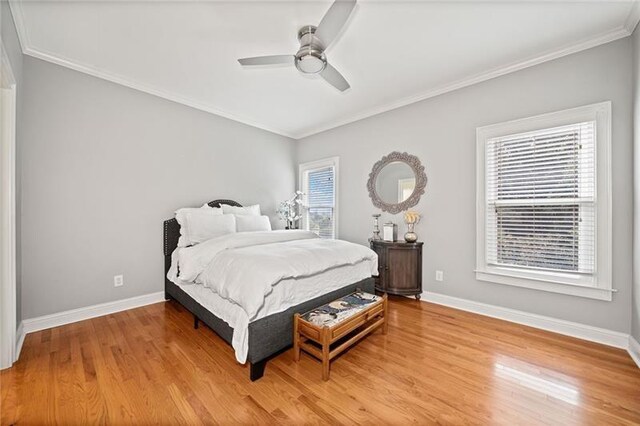 bedroom with multiple windows, ornamental molding, and hardwood / wood-style floors