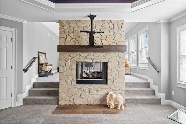 living room featuring carpet floors, crown molding, and a stone fireplace