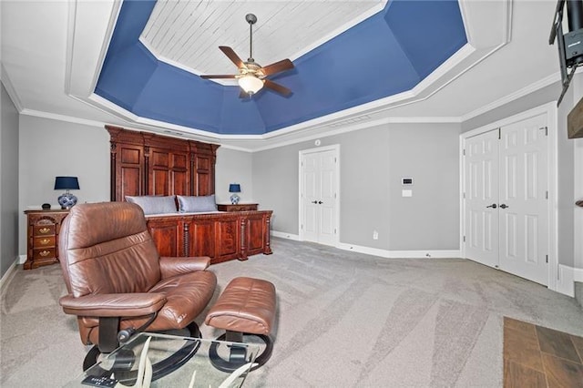 carpeted office featuring ceiling fan, ornamental molding, and a raised ceiling