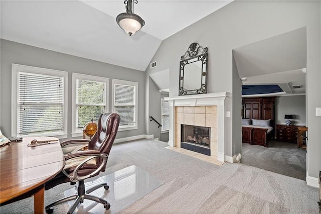 home office featuring lofted ceiling, light carpet, and a fireplace