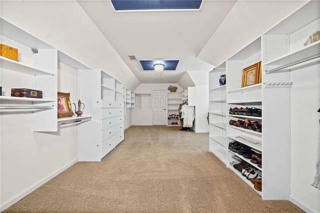 walk in closet with lofted ceiling and light carpet