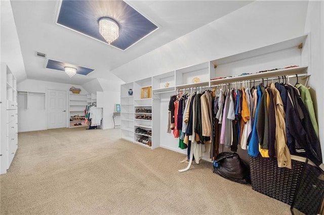 spacious closet with lofted ceiling and light carpet