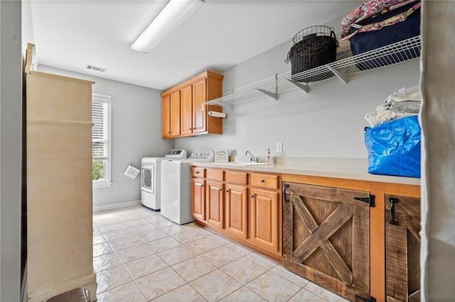 laundry room with cabinets, light tile patterned flooring, sink, and washer and clothes dryer