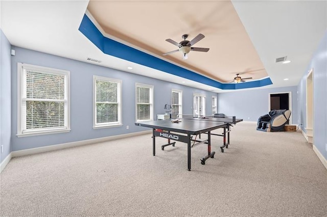 game room featuring ceiling fan, light colored carpet, and a raised ceiling