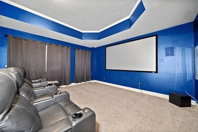 carpeted cinema with a raised ceiling