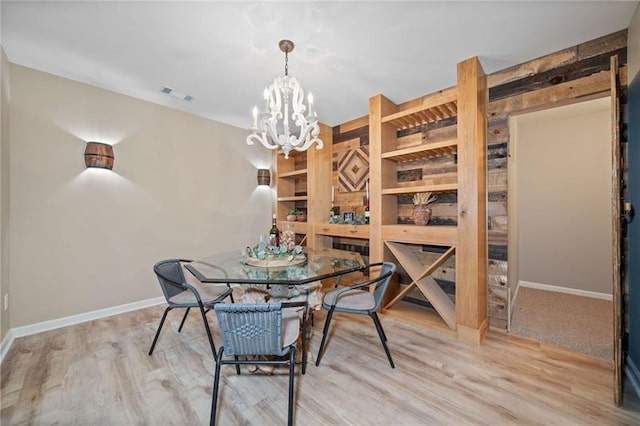 dining room featuring a notable chandelier and light wood-type flooring