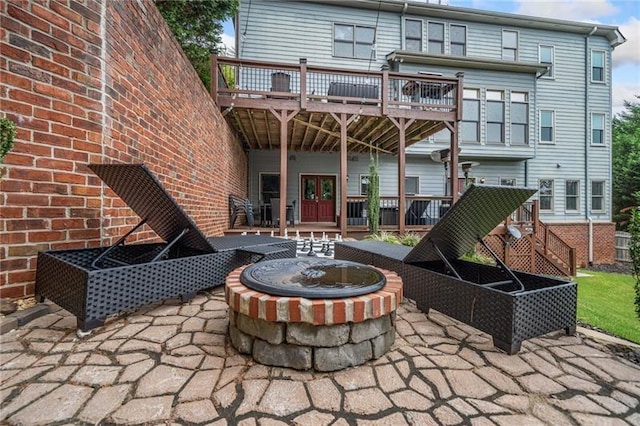 rear view of house with a patio area, a deck, and an outdoor fire pit