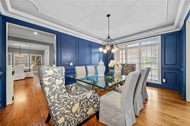 dining room with crown molding, a chandelier, and light hardwood / wood-style flooring