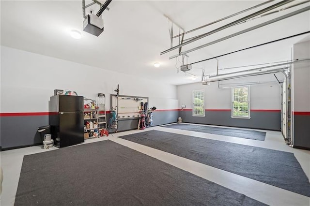 garage featuring black fridge and a garage door opener