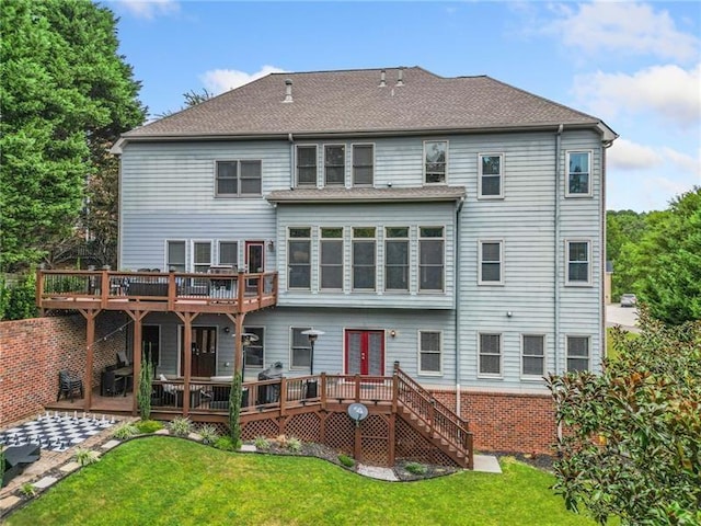 rear view of property featuring a wooden deck and a lawn