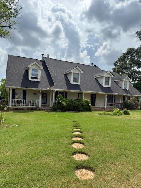 view of front facade featuring covered porch and a front lawn