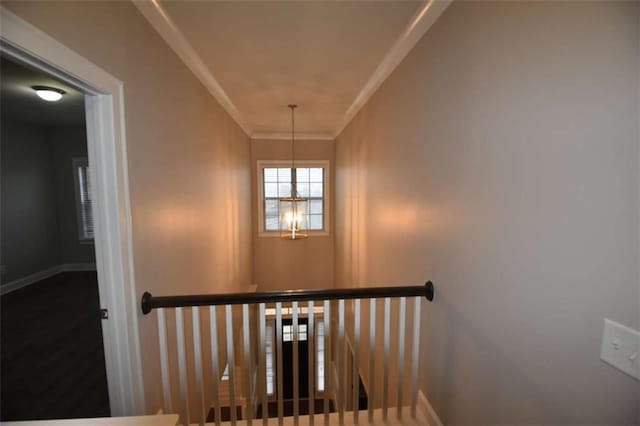 stairway with a chandelier and ornamental molding