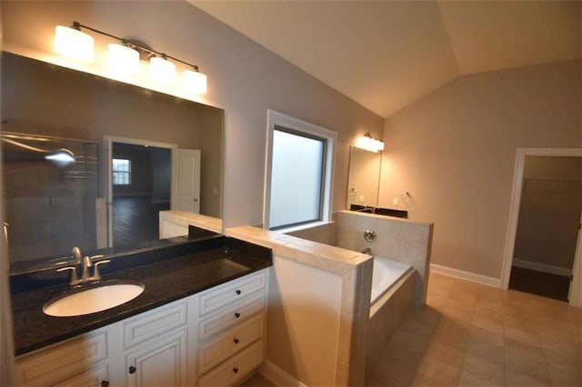 bathroom with tile patterned flooring, vanity, a tub to relax in, and lofted ceiling