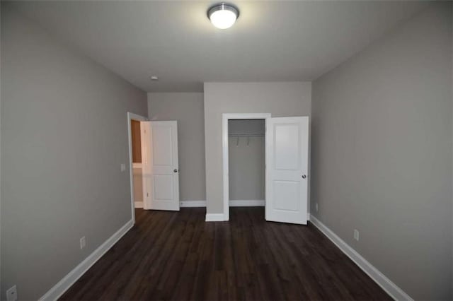 unfurnished bedroom with dark hardwood / wood-style flooring and a closet