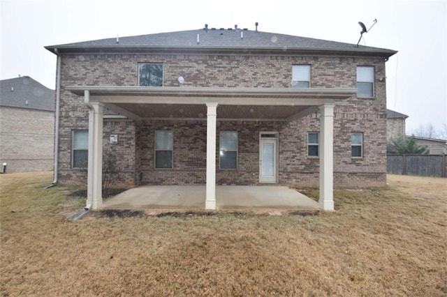 back of house with a lawn and a patio