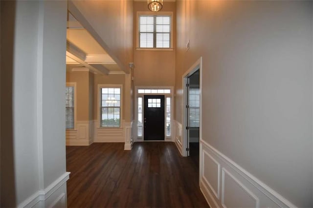 entrance foyer with dark hardwood / wood-style floors, beam ceiling, and coffered ceiling