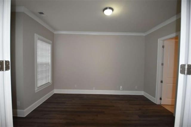 spare room featuring crown molding and dark wood-type flooring