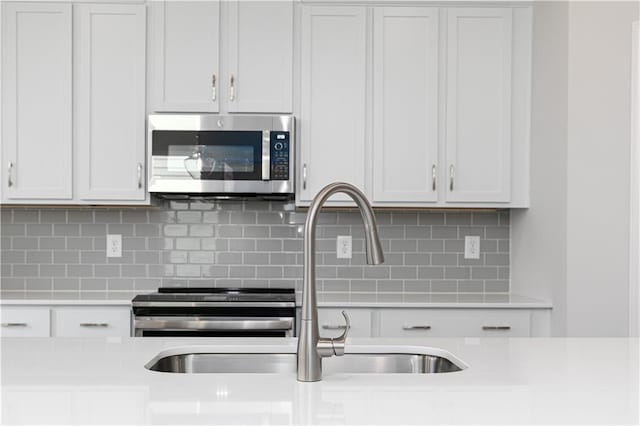805 York Aly, Acworth, GA 30102 - kitchen featuring stainless steel microwave, light countertops, backsplash, stove, and white cabinets