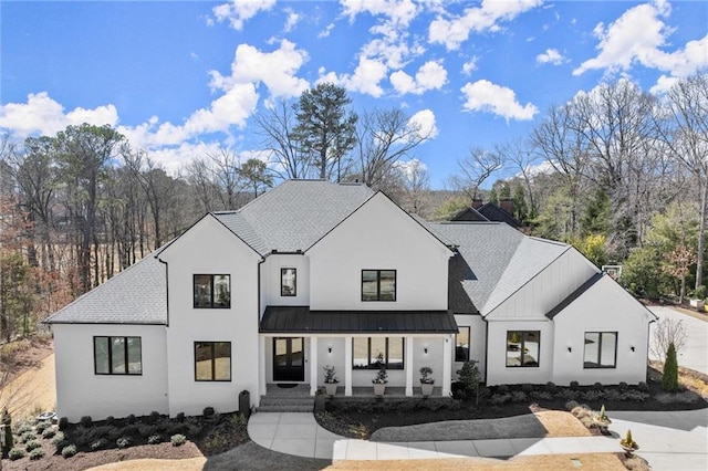 modern inspired farmhouse with metal roof, a standing seam roof, and roof with shingles