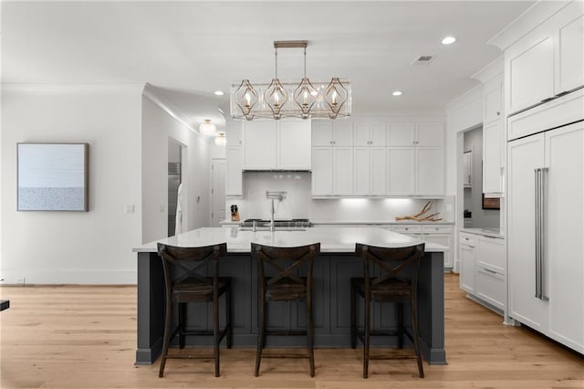 kitchen featuring white cabinetry, ornamental molding, and light countertops