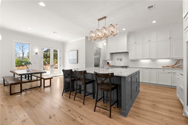 kitchen featuring visible vents, french doors, white cabinetry, and light wood-style floors