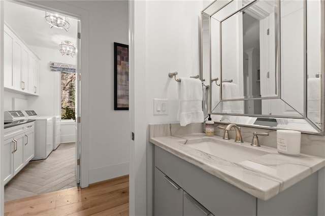 bathroom featuring parquet floors, baseboards, vanity, and washer and clothes dryer