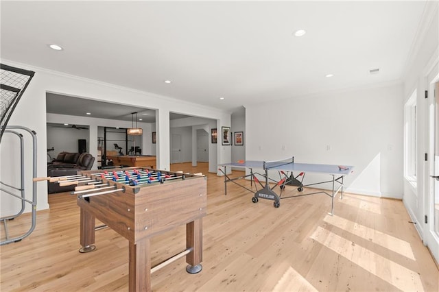 game room featuring crown molding, recessed lighting, baseboards, and light wood finished floors