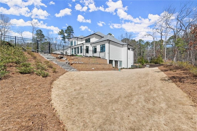 exterior space featuring stucco siding and fence