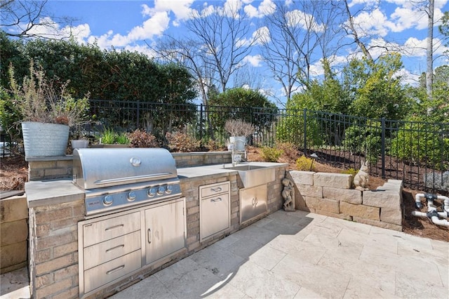 view of patio with area for grilling, an outdoor kitchen, and fence