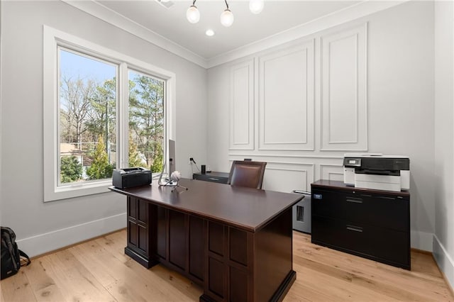 home office with baseboards, light wood-style floors, and ornamental molding