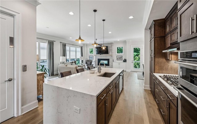 2059 Wheaton Way, Atlanta, GA 30328 - kitchen with a sink, a fireplace, appliances with stainless steel finishes, dark brown cabinets, and recessed lighting