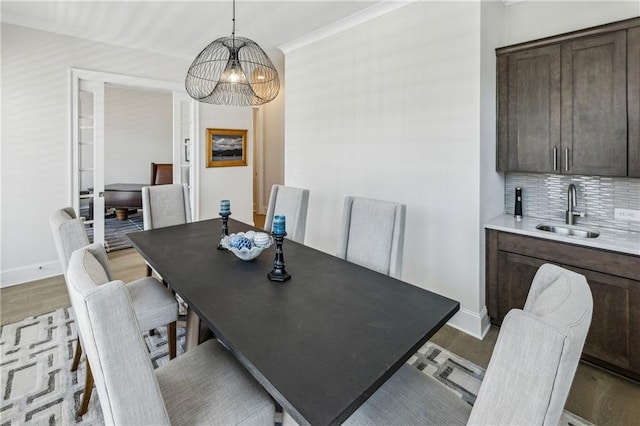 2059 Wheaton Way, Atlanta, GA 30328 - dining room featuring a chandelier, baseboards, crown molding, and bar with sink
