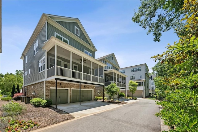 2059 Wheaton Way, Atlanta, GA 30328 - view of front facade with an attached garage, a sunroom, cooling unit, a ceiling fan, and driveway