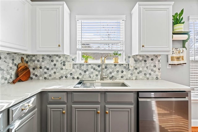 kitchen featuring white cabinets, dishwasher, gray cabinetry, and a sink