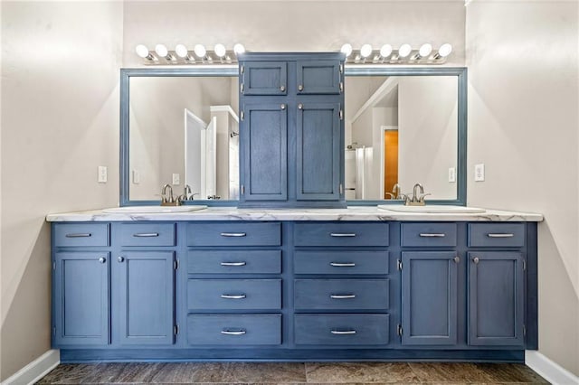 bathroom with a sink, baseboards, and double vanity